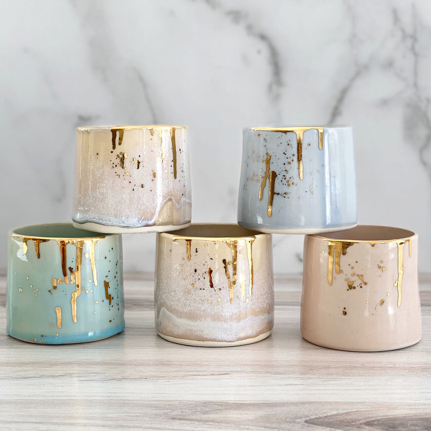 Noted Candles and Michelle Barrett Collaboration Vessels.Vessels have glazed ceramic finishes of assorted colors, all with real gold drips.